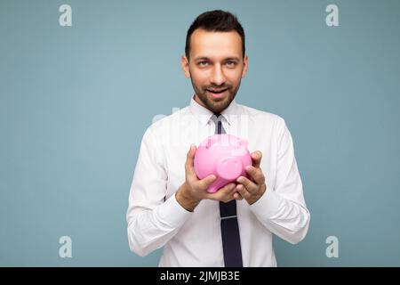 Photo of positive self-confident young handsome brunet unshaven male businessman with beard wearing casual white shirt and tie i Stock Photo