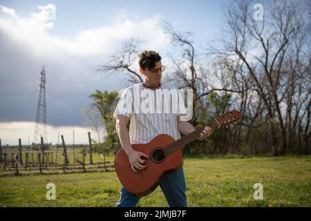 A musician plays classical guitar when outside in the fresh air Stock Photo