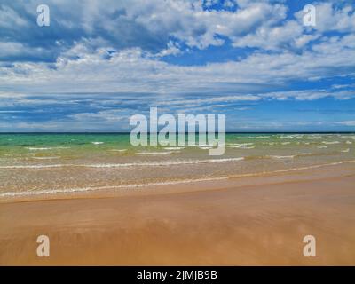 Clouds rolling in over a deserted tropical sandy beach Stock Photo