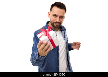 Young man on white background with white gift box with red bow Stock Photo