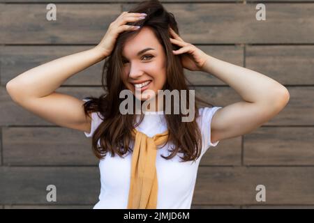 Close-up photo of pretty attractive beautiful smiling happy positive charming young brunette young woman wearing stylish clothes Stock Photo