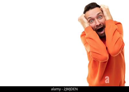 Young man holding his head with his hands in horror and fear Stock Photo