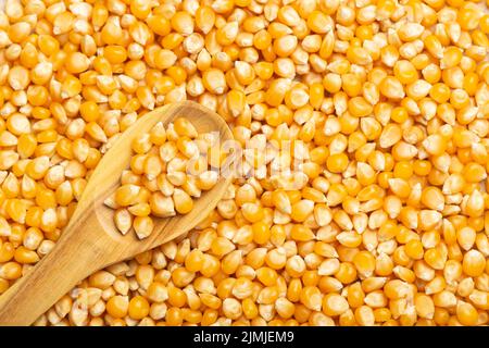 corn kernels for popcorn, in the wooden spoon, top view Stock Photo