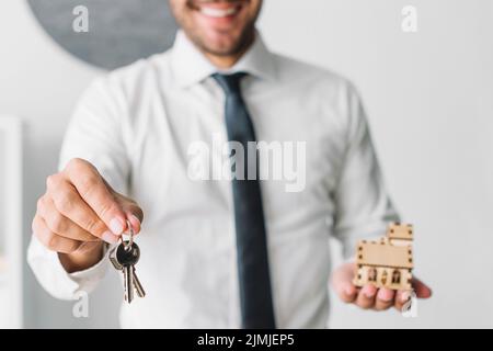 Crop real estate agent with keys house Stock Photo