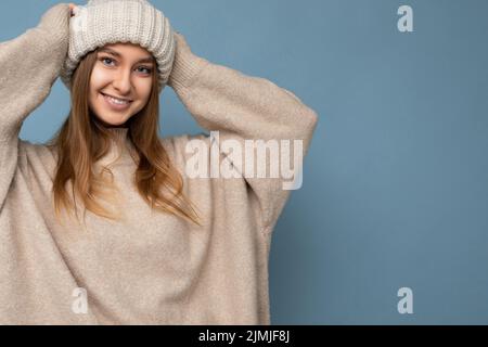 Portrait photo of attractive pretty beautiful positive happy smiling young dark blond woman isolated over blue background with e Stock Photo