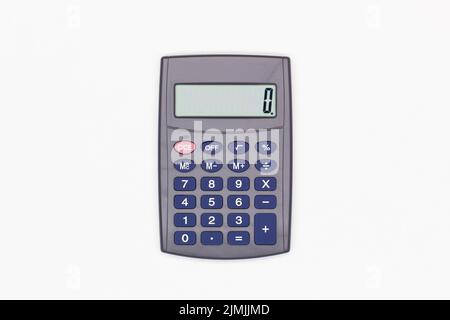 Calculator with big blue buttons and zero on the digital screen on a white background. Solar powered calculator. Electronic machine for math calculati Stock Photo