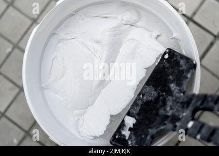 Texture of white plaster. Covering the concrete wall of the house. Rough surface. Repair and construction. Stock Photo