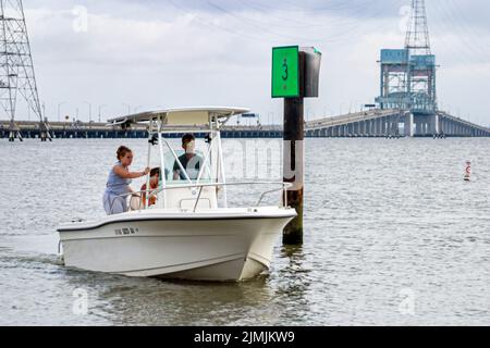 Virginia Newport News near James River Bridge,fishing recreation water dock pier man woman couple riding operating fishing boat boating,visitors Stock Photo