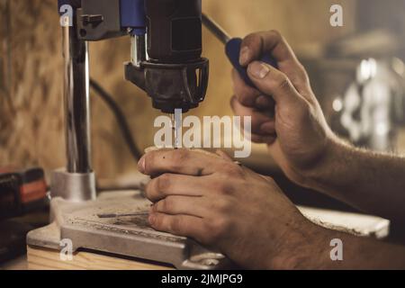 Carpenter is working on the drill machine Stock Photo