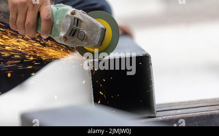 Unsafe on protection of construction worker while use grinder machine cutting steel in constuction site Stock Photo
