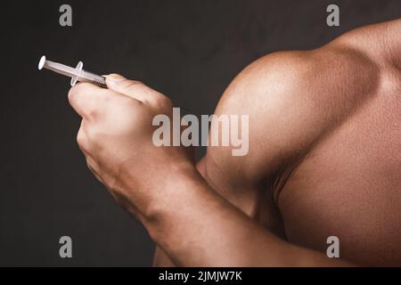 Muscular man with a syringe in his hand Stock Photo