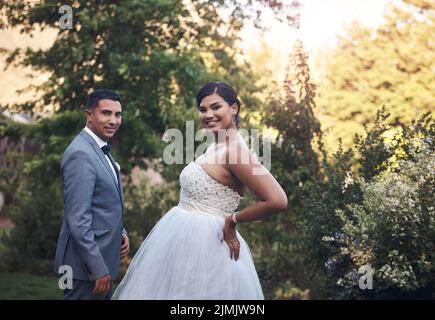 Look stunning on their special day. a young couple posing outside on their wedding day. Stock Photo