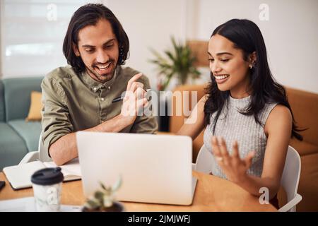 Teamwork is what gets the job done quicker. Portrait of two businesspeople working together on a laptop in an office. Stock Photo