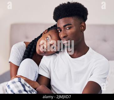 Love is worth it. an affectionate couple relaxing on their bed wearing pajamas. Stock Photo