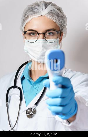 Doctor is measuring your body temperature with a digital infrared thermometer Stock Photo