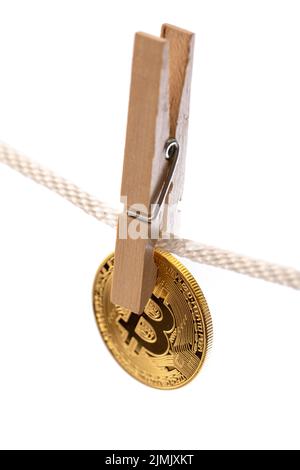 Bitcoin is hung on a rope with clothespins. Stock Photo