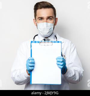Doctor is holding a clipboard with a sheet of blank white paper Stock Photo