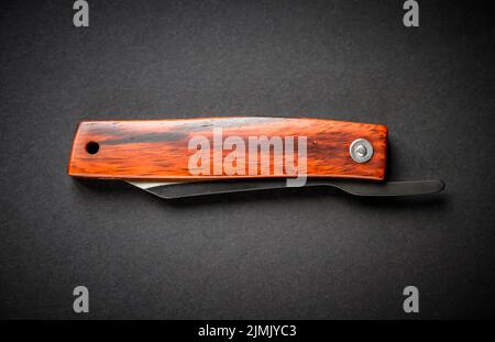 Traditional wooden japanese pocket knife on black background Stock Photo