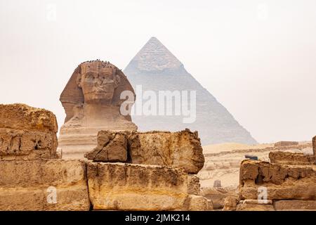 View of Statue of The Great Sphinx of Giza in The Giza Plateau and The Great Pyramid of Giza in the background. Stock Photo