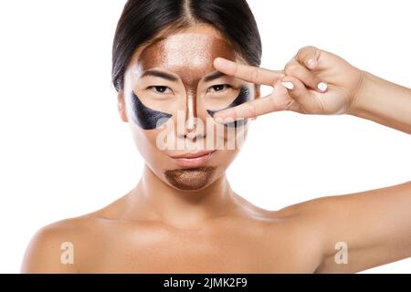 Young asian woman with a purifying peel-off mask on her face Stock Photo