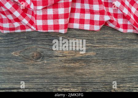 Red checkered towel on the kitchen table. Wooden table background. Stock Photo