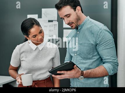 These two are known to produce the best work together. two architects working together on a digital tablet in an office. Stock Photo