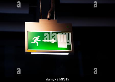 Emergency exit, illuminated green board Stock Photo