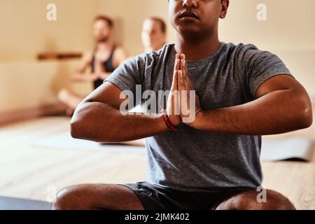 Immersed in the magic of yoga. a group of young men and women meditating in a yoga class. Stock Photo