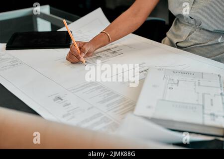 Its the details that matter. an unrecognizable architect working on blueprints. Stock Photo