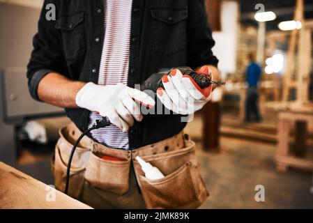 Im ready to get my drill on. an unrecognizable carpenter holding an electric drill inside a workshop. Stock Photo