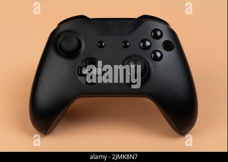 Black game controller front view isolated on brown background Stock Photo