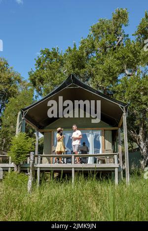 Couple men and woman in front of safari tent on a luxury safary,South Africa, luxury safari lodge in the bush Stock Photo