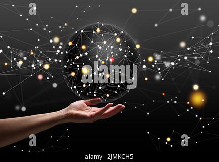 A female hand holds a sphere with global international connections. Futuristic visualization of global business and world intern Stock Photo