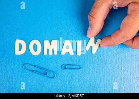 Domain. Text from white wooden letters on a blue background. Stock Photo