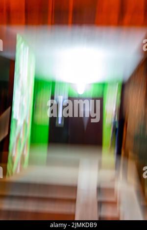 Defocused view of illuminated night entrance. A glitch in the eyes of a drunk or a drug addict. Stock Photo