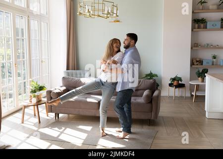 Couple in love dance in fashionable sunny living room Stock Photo