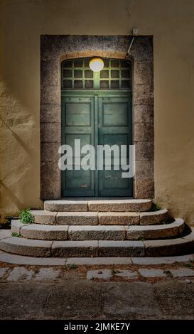 Double wooden door lit by lamp. Stock Photo