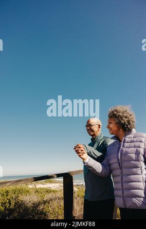 Senior Retired Couple Walking Along Beach Hand In Hand Together Stock ...