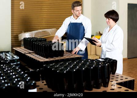 Employees checking number of wine bottles Stock Photo