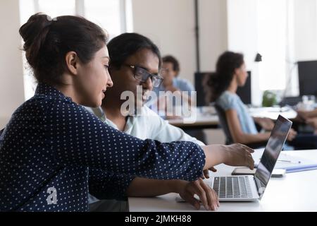 Indian employees discuss on-line project using laptop Stock Photo