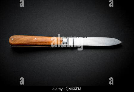 Traditional wooden pocket knife on black background Stock Photo