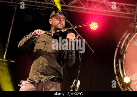 Dan Booth, violinist and fiddle player with British folk band Ferocious Dog seen performing live on stage at Wickham Festival. Ferocious Dog is a six-piece band who deals in a vibrant vein of Celtic-folk infused punk rock, comfortably slotting in between Billy Bragg and The Levellers. The band has headlined tours of the UK and Europe, performed in Kenya and Dubai, festivals such as Bearded Theory, Alchemy, Deerstock, Farmer Phil's Festival, Splendour, Lowlands (Netherlands), Glastonbury Festival and Beautiful Days among many other. Stock Photo