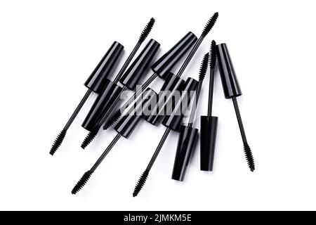 Black mascara brushes and containers on white background Stock Photo