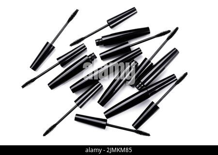 Black mascara brushes and containers on white background Stock Photo