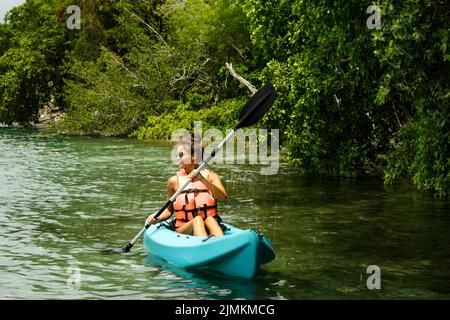 Happy young woman kayaking on the lake Stock Photo