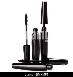 Black mascara brushes and containers on white background Stock Photo