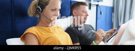 Woman with laptop and man with tablet in bed, freelancing Stock Photo