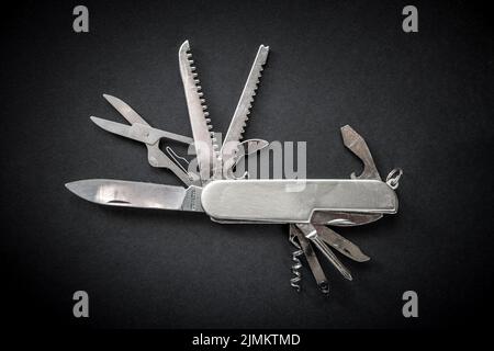Metallic swiss knife isolated on black Stock Photo