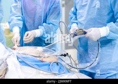 A team of surgeons operates on a patient on an operating table. Stock Photo