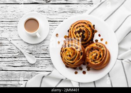 Delicious cinnamon raisins rolls wooden table Stock Photo